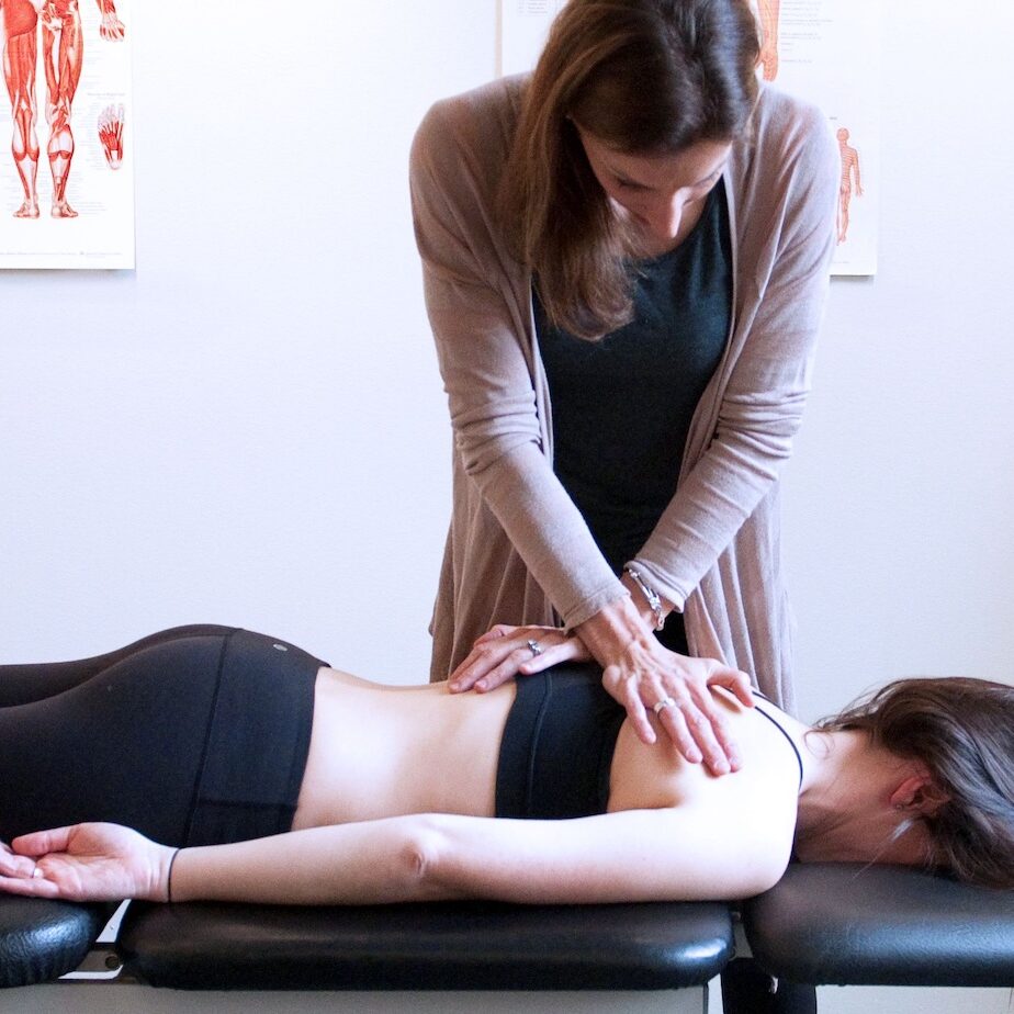 Physiotherapist helping a patient with rehabilitation exercises in a bright, modern Envision Physiotherapy clinic overlooking Vancouver mountains